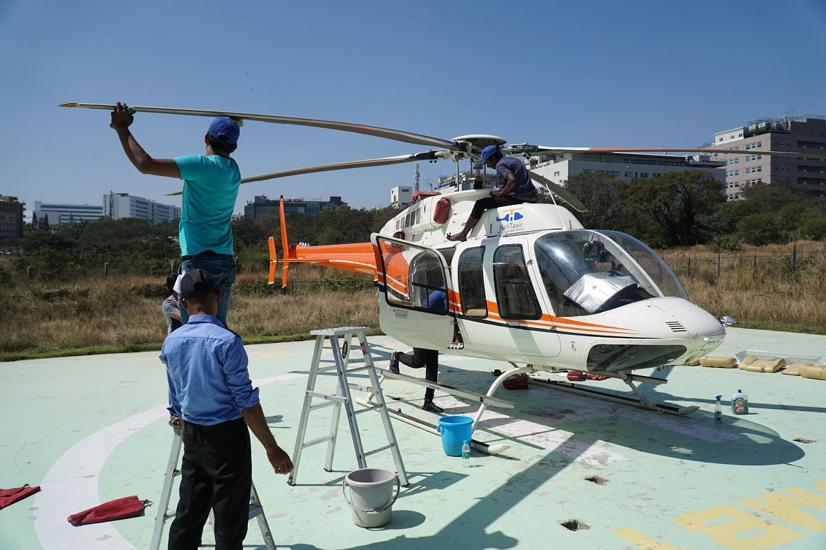 Staff clean a four-bladed, single-engined Bell 407 utility helicopter of Thumby Aviation at Electronics City. The aircraft which is capable of seating six people, was used as part of shuttle service from Electronics City to a helipad at BIAL from March 20