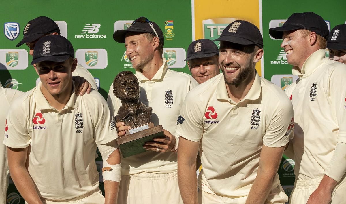 England's captain Joe Root, center, with teammates pose for photographers after receiving their trophy at the end of day four of the fourth cricket test match between South Africa and England at the Wanderers stadium in Johannesburg, South Africa, Monday,