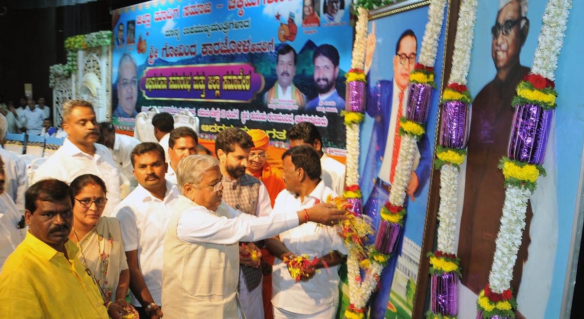 Deputy Chief Minister Govind M Karjol pays floral tributes to the portraits of Dr B R Ambedkar and Babu Jagjivan Ram during Jilla Madigara Samavesha in Chikkamagaluru.