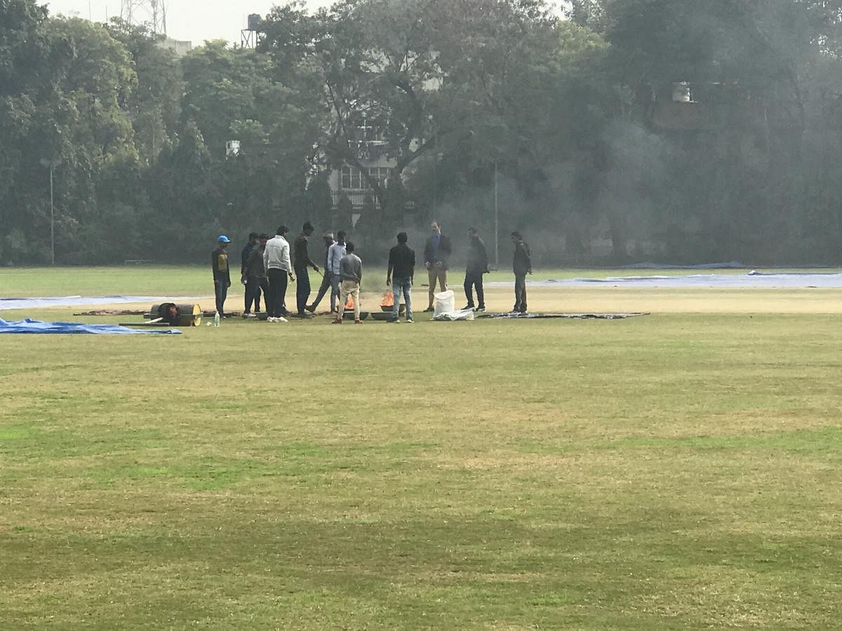 Groundsmen at the Karnail Singh stadium attempt to dry the pitch after early morning rain delayed the second day’s play between Railways and Karnataka. dh photo/ROSHAN THYAGARAJAN