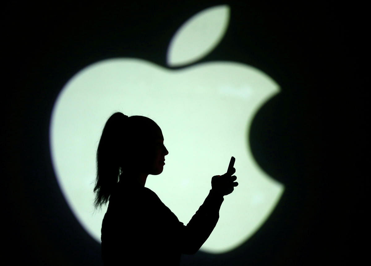 FILE PHOTO: Silhouette of mobile user is seen next to a screen projection of Apple logo in this picture illustration taken March 28, 2018. (Credit: REUTERS/Dado Ruvic/Illustration/File Photo)