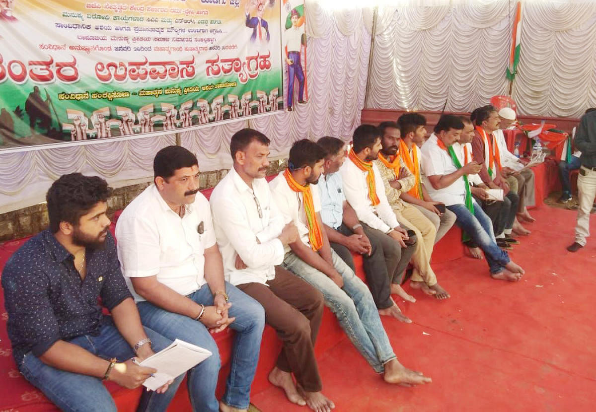Youth Congress members don saffron shawls while extending their support to the hunger strike being staged by Pragatipara Janandolana Vedike opposing Citizenship (Amendment) Act at Gandhi Maidan in Madikeri on Wednesday. DH Photo