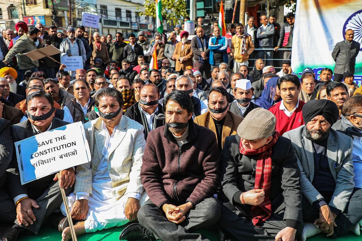 JKPCC Chief  G A Mir (sitting at centre in the front row) along with other senior Congress leaders take part in a demonstration to save constitution after paying homage to Mahatma Gandhi on his 72nd death anniversary. PTI
