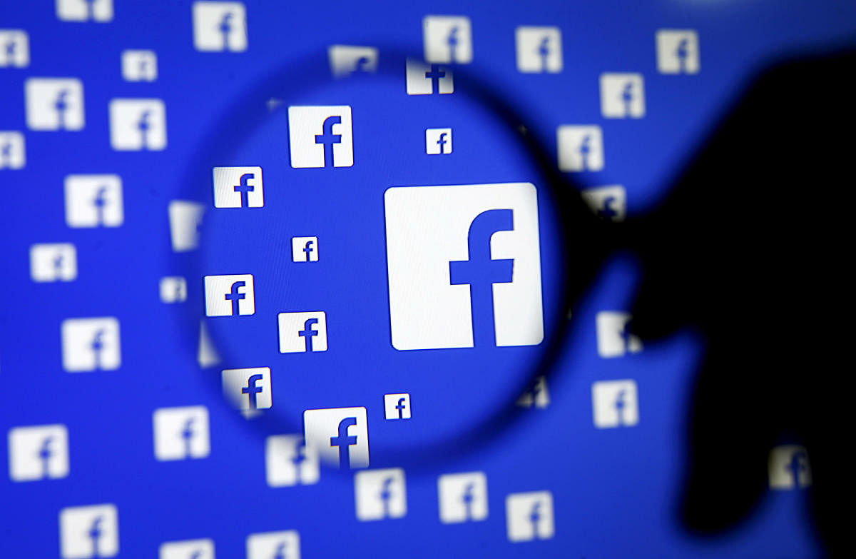 A man poses with a magnifier in front of a Facebook logo on display in this illustration taken in Sarajevo, Bosnia and Herzegovina. (Reuters photo)
