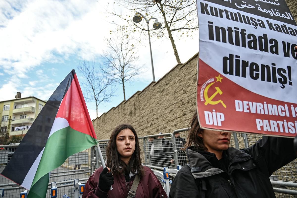 Protester hold a Palestine flag and a placard reading "Resistance until libaration" as they take part in a demonstration in front of the US consulate to protest against the US peace plan in Istanbul, on January 29, 2020. Credit: AFP Photo