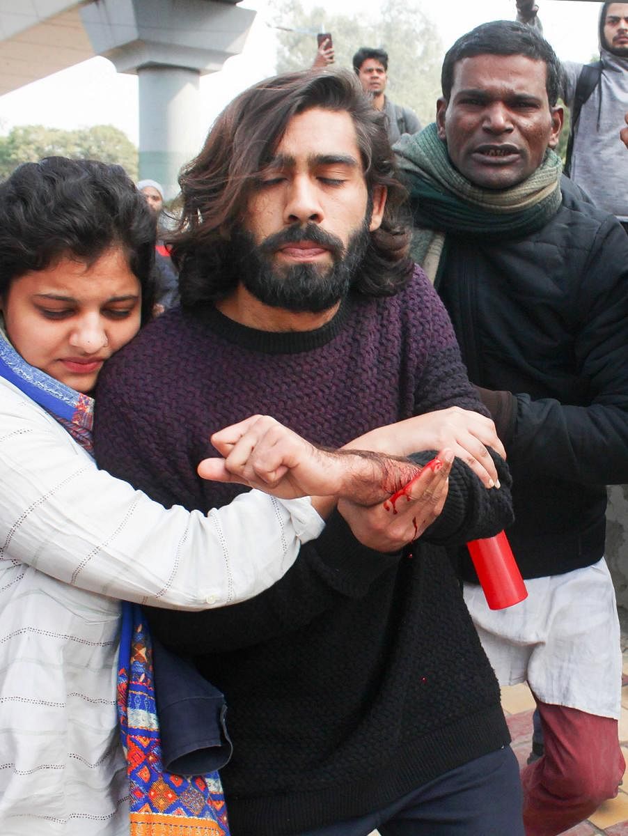 An student (C) of the Jamia Millia Islamia university, injured after an unidentified person allegedly opened firing during an anti-CAA protest. (PTI Photo)