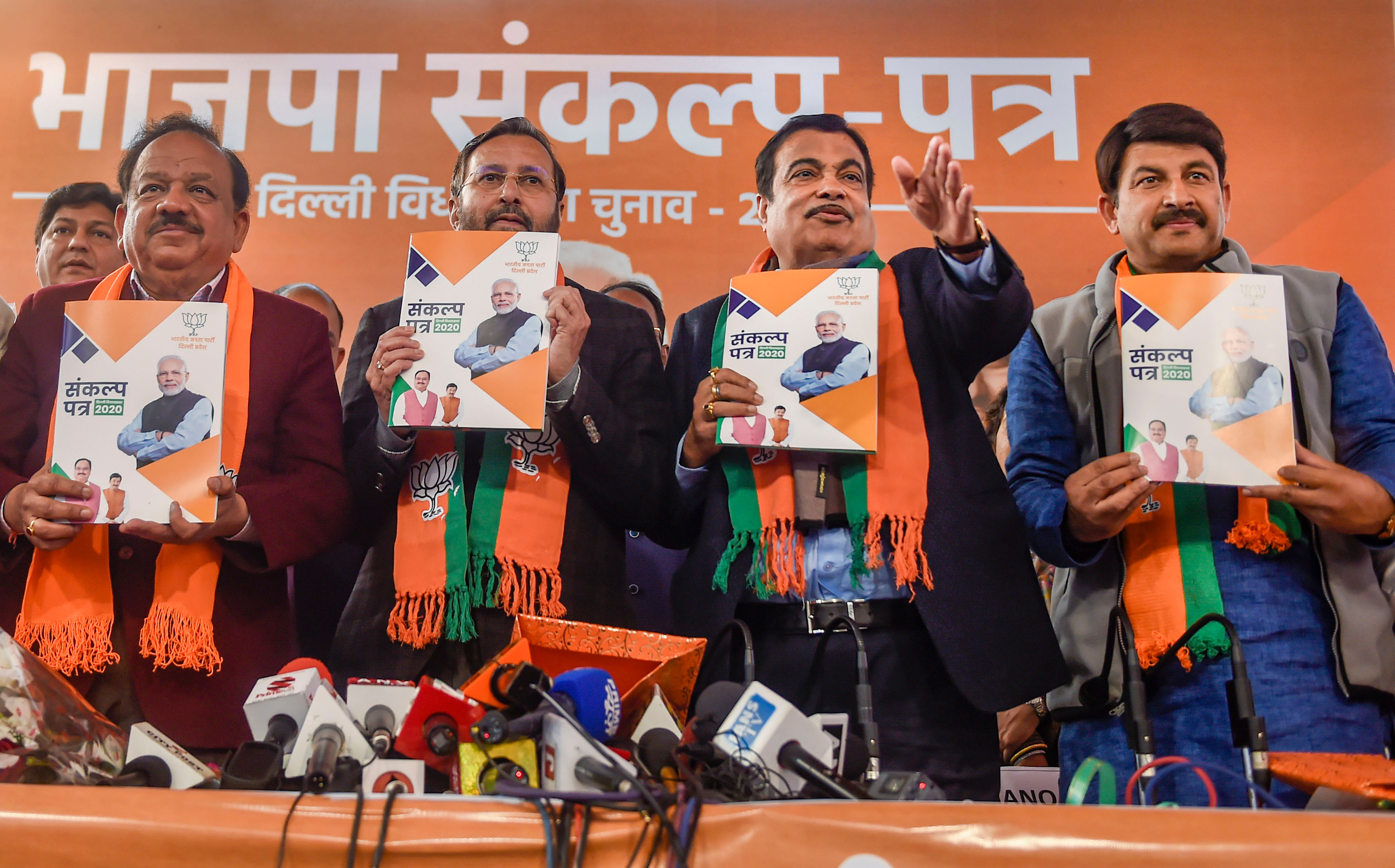 Union ministers and BJP leaders Nitin Gadkari (C-R), Prakash Javadekar (C-L) and Harsh Vardhan (L) along with Delhi BJP President Manoj Tiwari (R) release the 'BJP Sankalp Patra for Delhi Assembly Elections 2020, in New Delhi, Friday, Jan. 31, 2020. (Credit: PTI Photo)