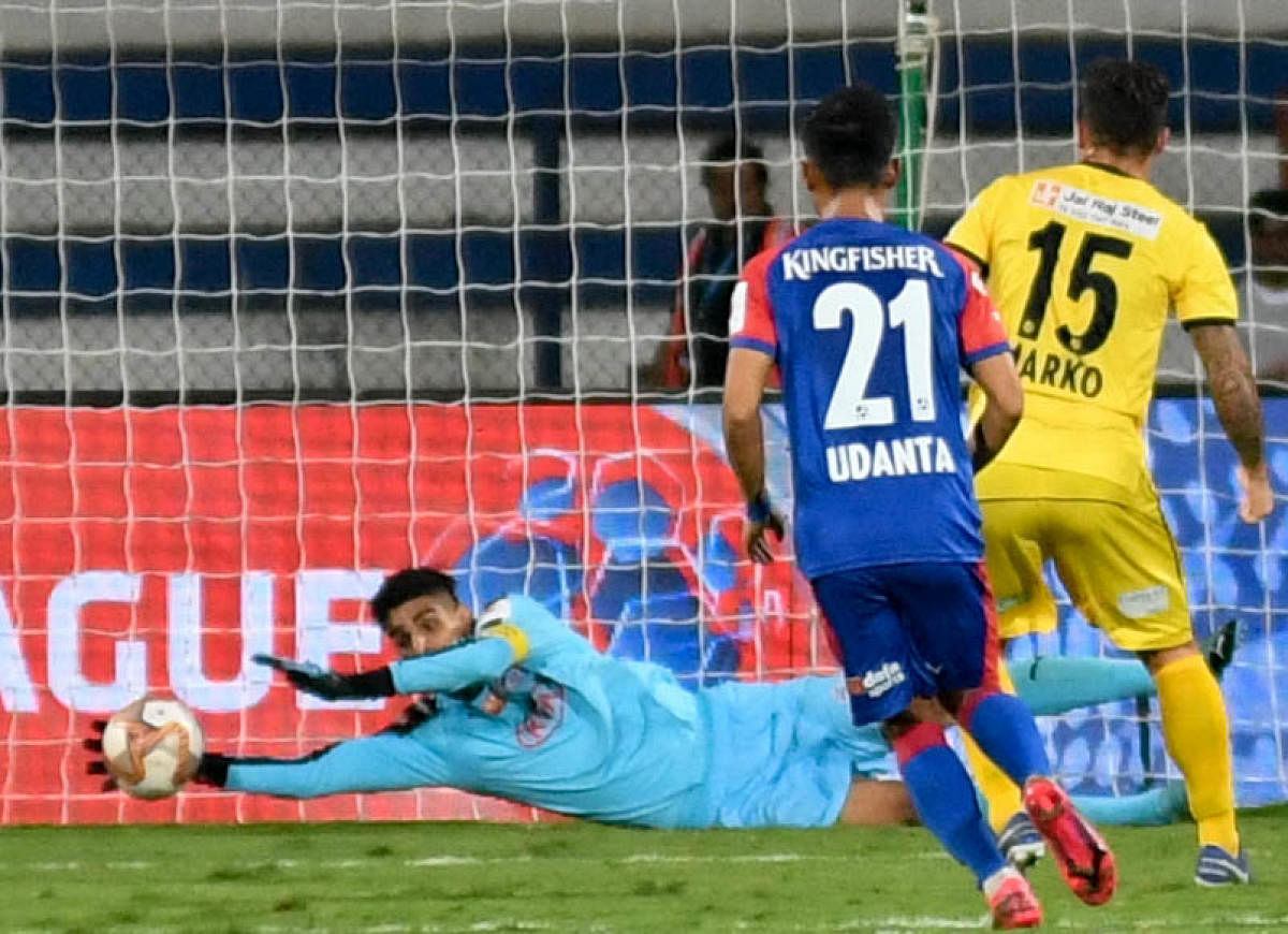 Bengaluru FC goalkeeper Gurpreet Singh dives full length to stop a penalty from Marcelinho of Hyderabad FC during their ISL clash on Thursday. DH PHOTO/ BH SHIVAKUMAR 