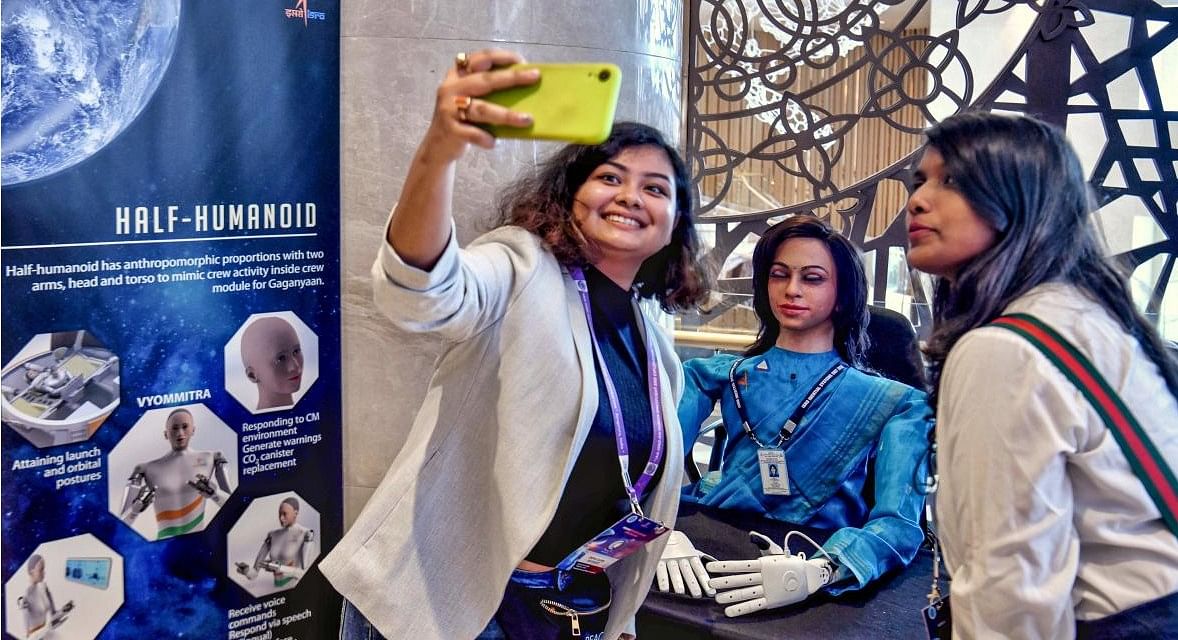 Visitors take selfies with 'Vyommitra' the first prototype half humanoid robot developed by the Inertial Systems Unit of Indian Space Research Organisation (ISRO) for its planned 'Gaganyaan' unmanned mission at an exhibition during a symposium on Human Spaceflight and Exploration - Present Challenges and Future Trends in Bangalore on January 23, 2020. (Photo by Manjunath Kiran / AFP)