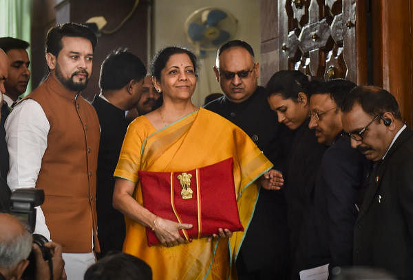 Union Finance Minister Nirmala Sitharaman, flanked by her deputy Anurag Thakur (to her right) and a team of officials, shows a folder containing the Union Budget documents as she poses for lensmen on her arrival at Parliament in New Delhi, Saturday, Feb. 1, 2020. (PTI Photo)