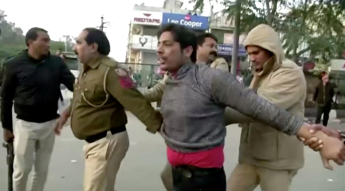 Police officers detain a man, who identified himself as Kapil Gujjar, who fired multiple shots at a site where people were protesting against a new citizenship law in New Delhi. Reuters