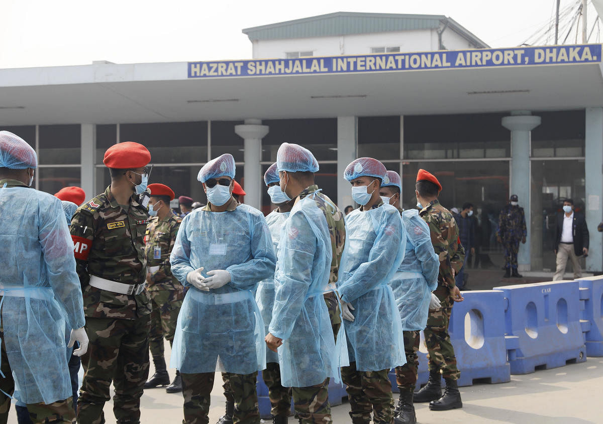 Bangladesh security officers wear protective gear and wait for the arrival of citizens who were brought back in a special aircraft from Wuhan, at the airport in Dhaka, Bangladesh. AP/PTI