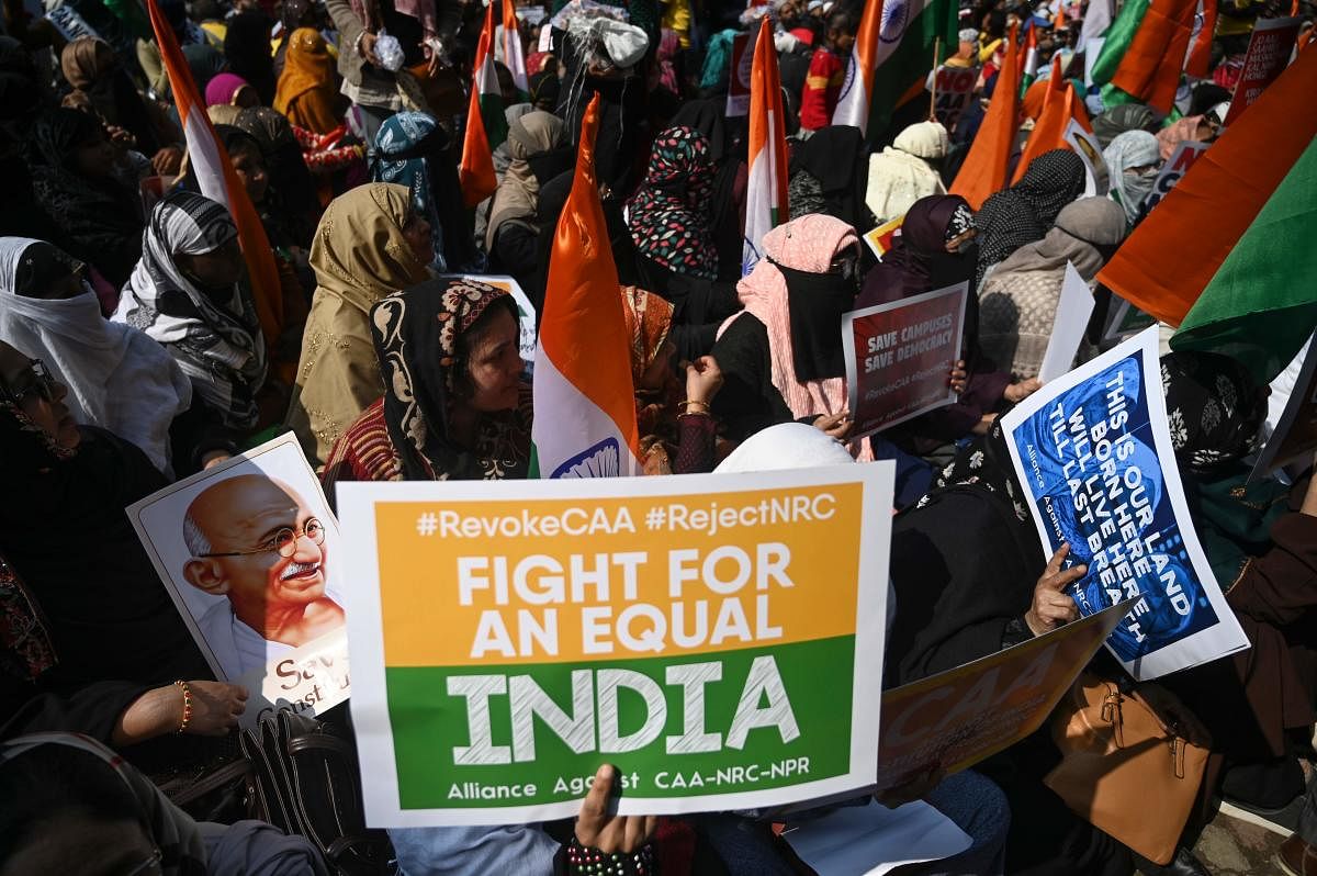 Protesters from Shaheen Bagh hold placards as they take part in a demonstration against India's new citizenship law (AFP Photo)