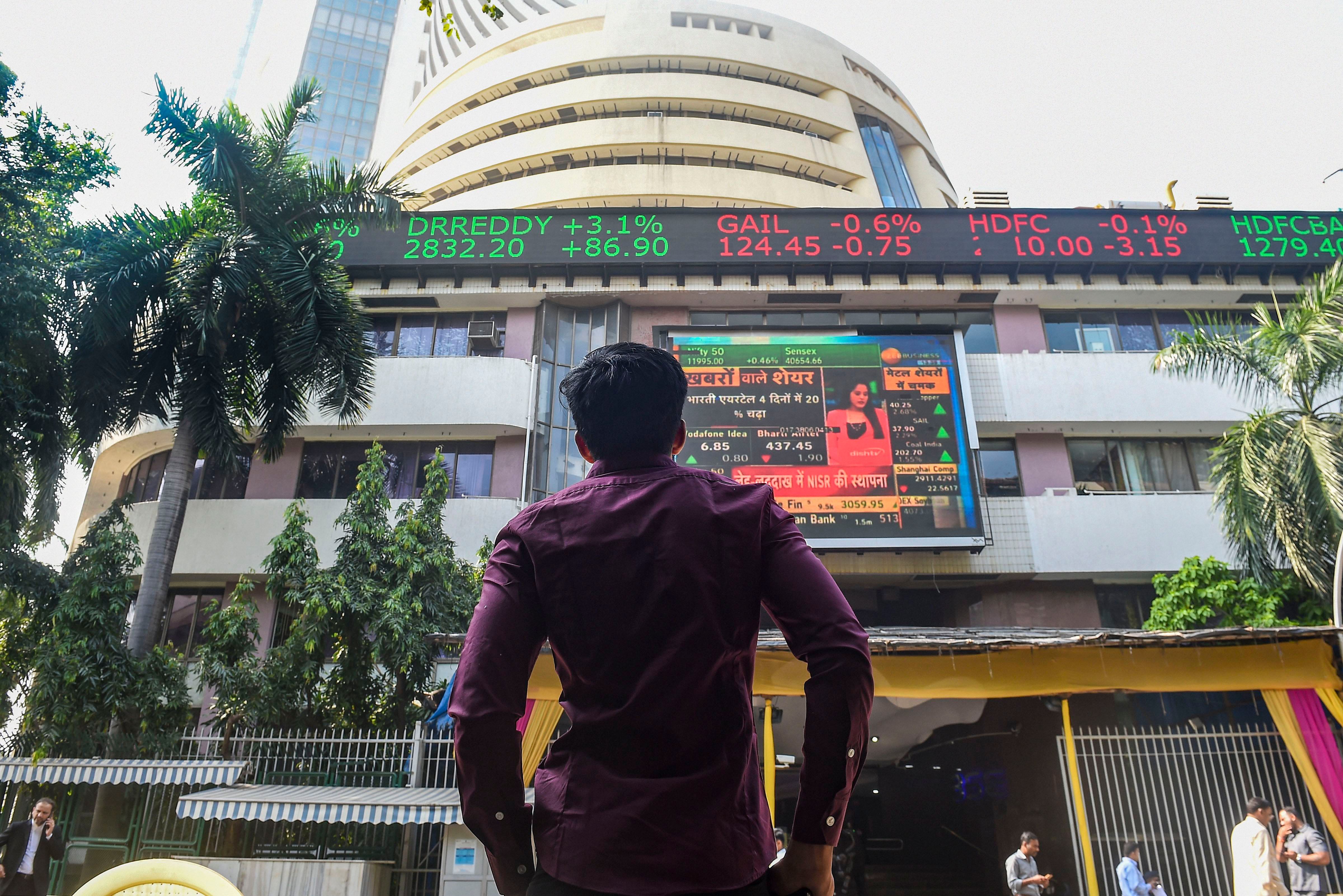 A bystander watches the stock prices displayed on a digital screen at the facade of the Bombay Stock Exchange (BSE) building, in Mumbai. (PTI Photo)