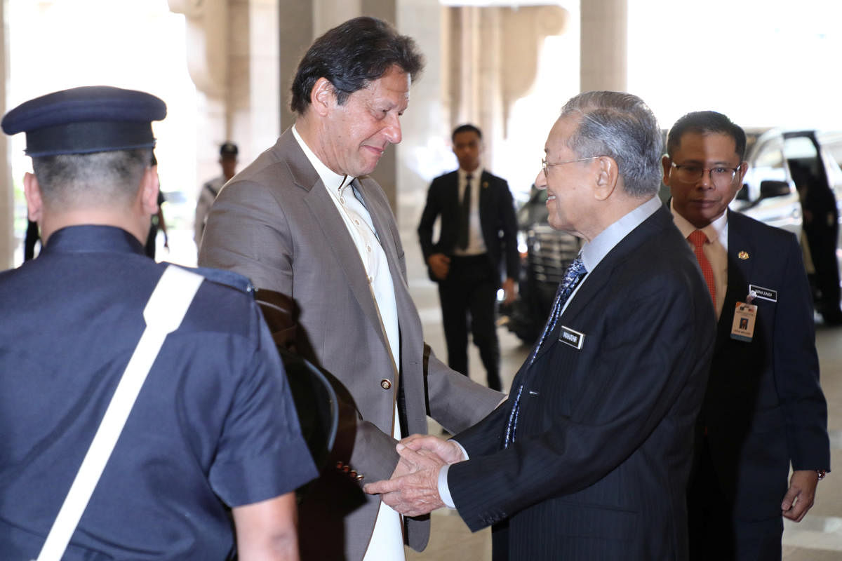 Pakistan's Prime Minister Imran Khan shakes hands with Malaysia's Prime Minister Mahathir Mohamad during his arrival at Malaysia Prime Minister Office in Putrajaya. Reuters