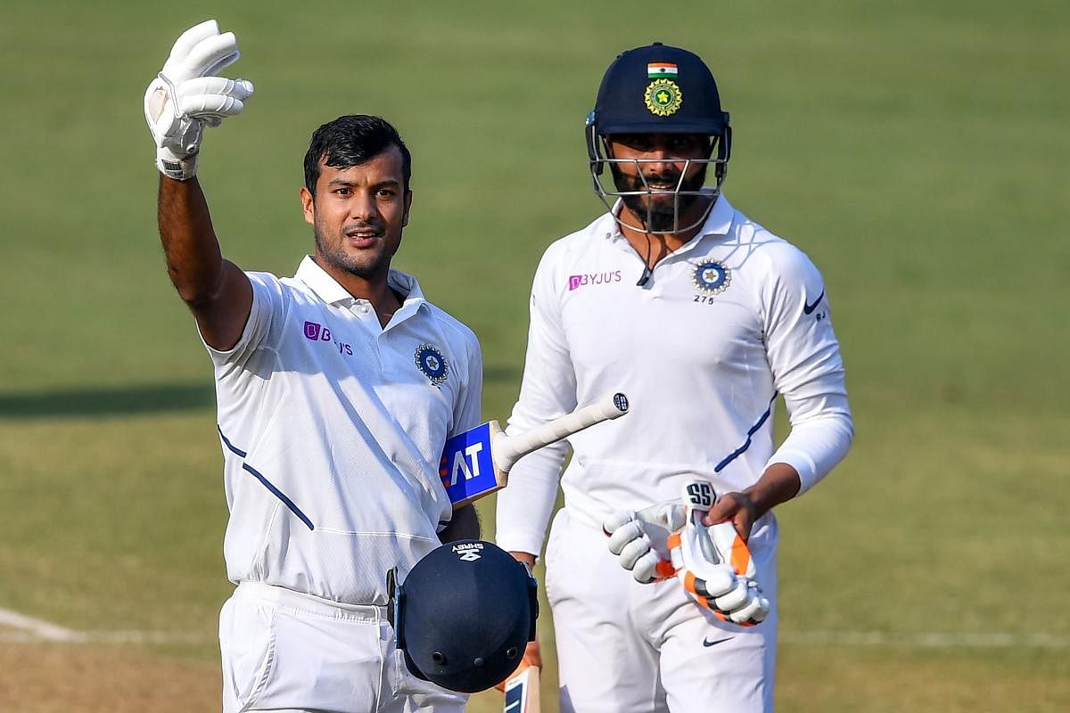 India's Mayank Agarwal (L) flashes two fingers after scoring a double-century (200 runs) as teammate Ravindra Jadeja looks on during the second day of the first Test cricket match of a two-match series between India and Bangladesh at Holkar Cricket Stadiu