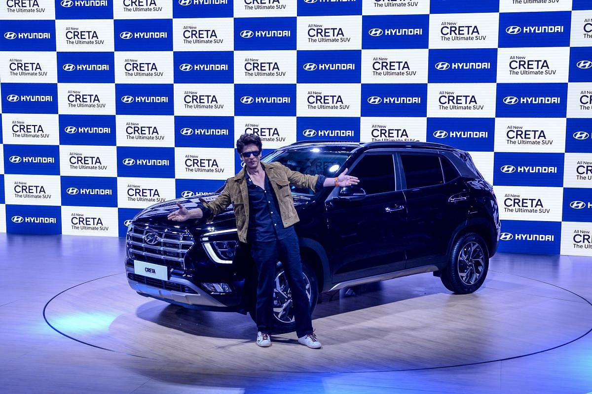 Bollywood actor Shah Rukh Khan gestures as he poses next to the newly launched Hyundai Creta SUV at the Auto Expo 2020 at Greater Noida. AFP