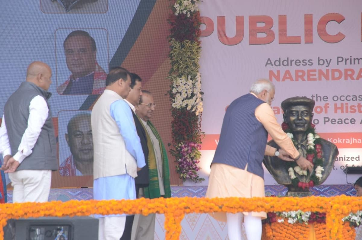 PM Narendra Modi pays tribute to UN Brahma, considered as father of the Bodos, who started the Bodoland Movement as Hagrama Mohilary (in white shirt) looked on. (Photo credit: Assam govt).
