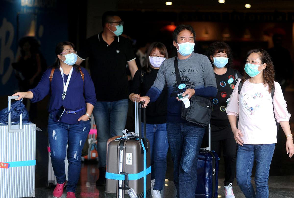 Passengers wearing medical masks walk at the international arrivals terminal of I Gusti Ngurah Rai airport, following an outbreak of the new coronavirus in China, in Bali. (Reuters Photo)