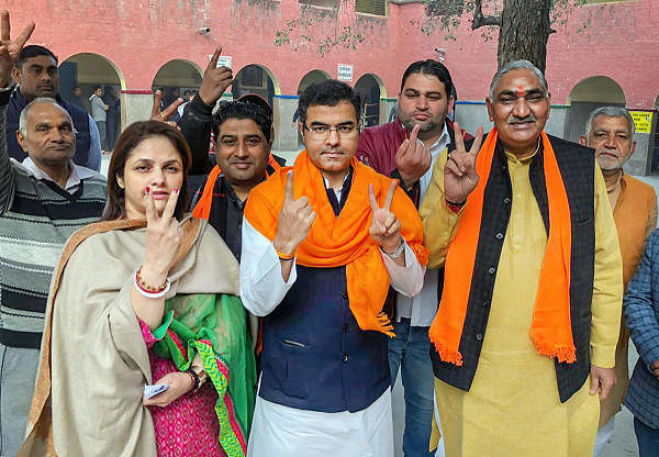 BJP West Delhi MP Parvesh Verma (C) and his wife Swati Singh Verma (R) show their finger marked with indelible ink after casting vote during the Delhi Assembly elections at Matiala polling station, in New Delhi, Saturday, Feb. 8, 2020. (PTI Photo)