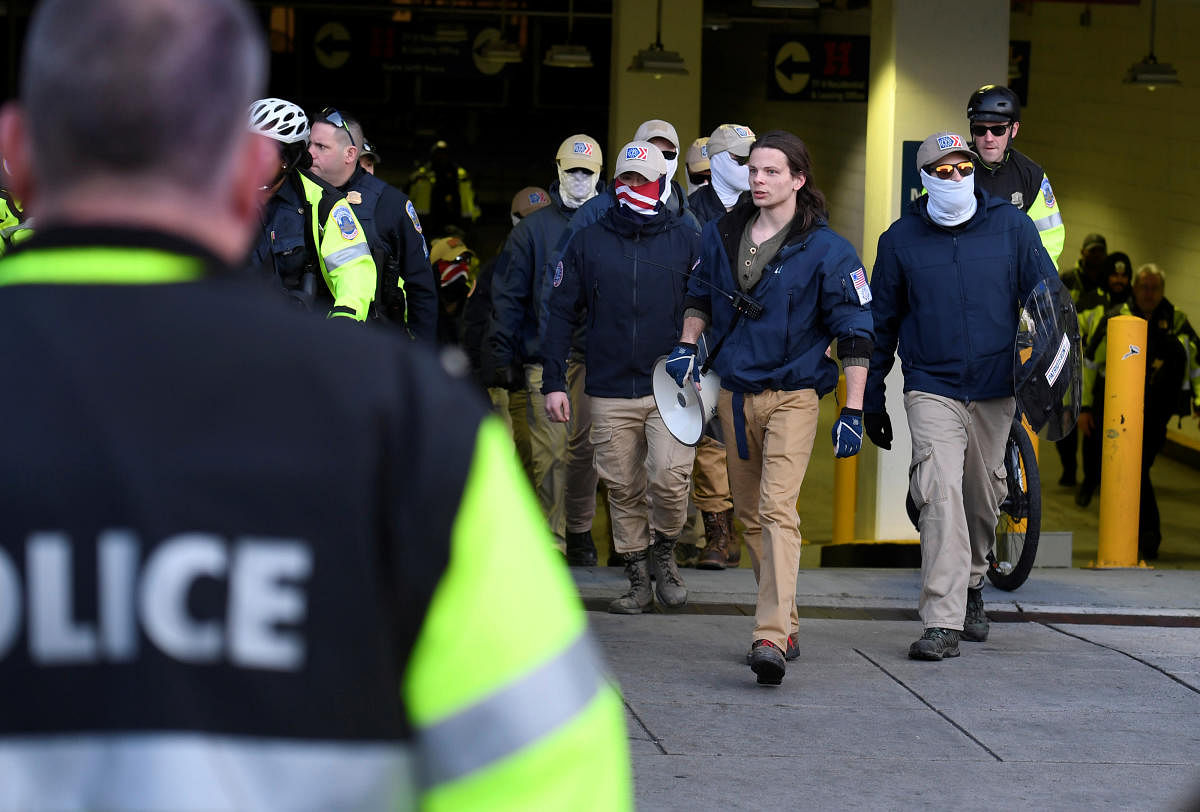 Police escort the last of about 150 masked members of the Patriot Front from a parking garage, after they peacefully ended a march near Capitol Hill, in Washington, U.S., February 8, 2020. Reuters