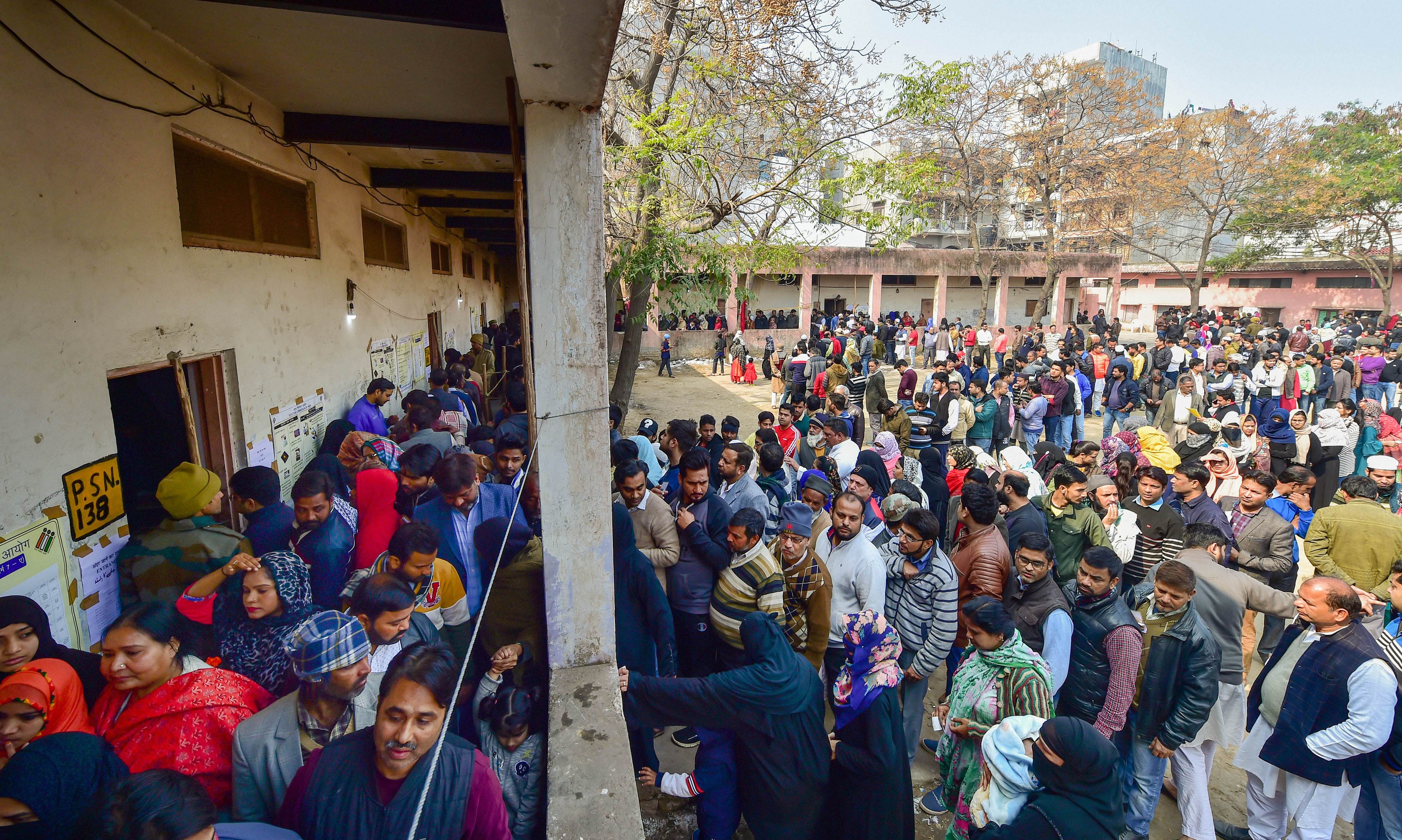 Voters wait in queues at the Abul Kalam Azad school polling station in Shaheen Bagh area, which has been witnessing a peaceful protest against the Citizenship Act for several weeks, during the Delhi Assembly elections, in New Delhi. (PTI Photo)