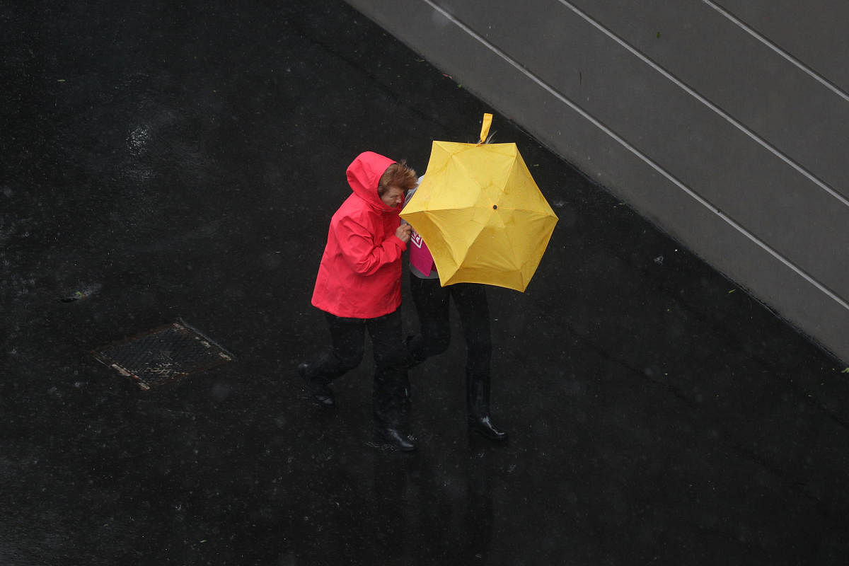 Pedestrians brave strong wind and rain in Sydney. Reuters