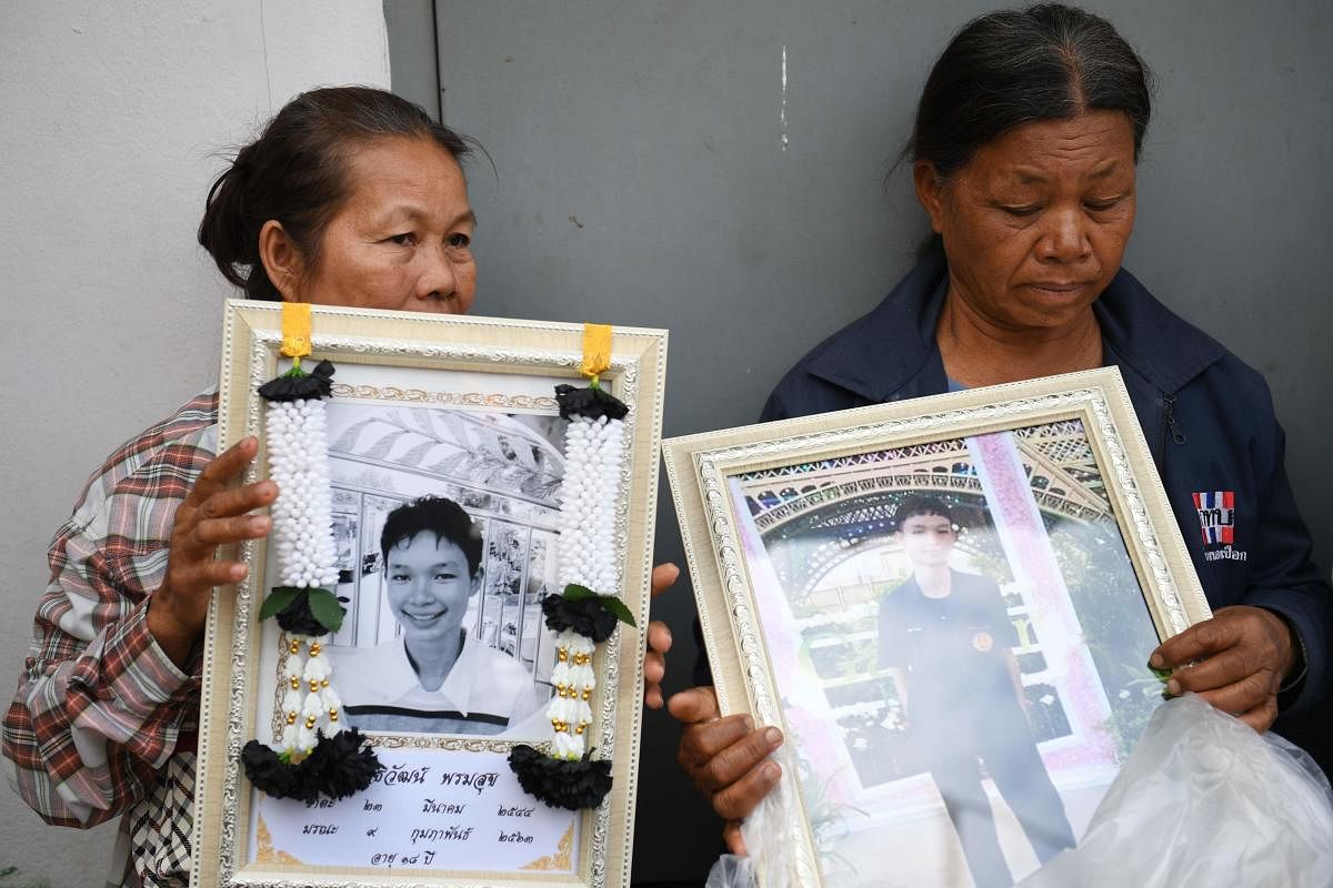 SHOOTING Relatives of Atiwat Promsuk, who was killed in a mass shooting at the Terminal 21 shopping mall, hold his portrait as they wait to collect his body at a morgue in the Thai northeastern city of Nakhon Ratchasima on February 10, 2020. (Photo by AFP)