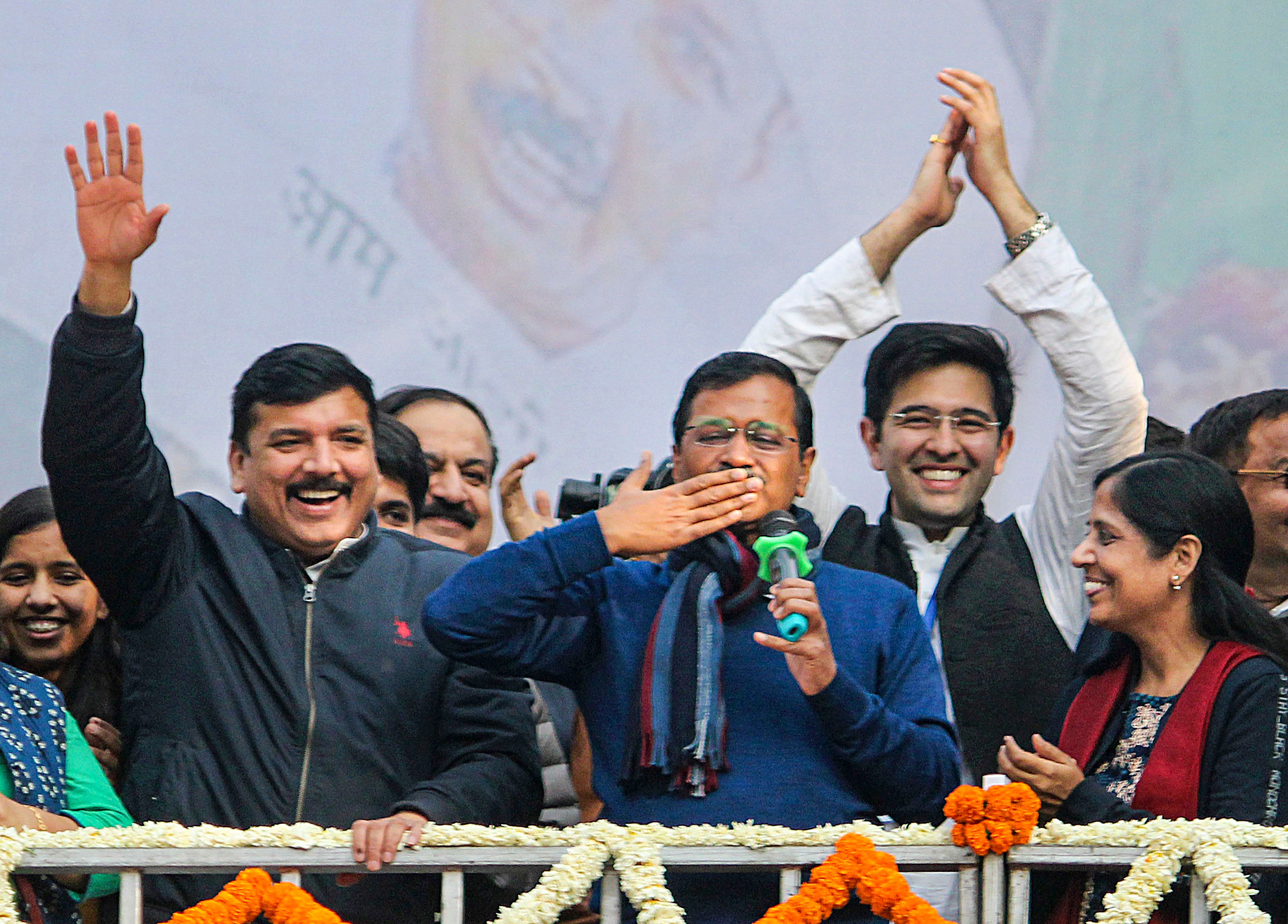 Delhi CM and AAP convenor Arvind Kejriwal (C) gestures during his address to supporters after party's victory in the State Assembly polls, at AAP office in New Delhi, Tuesday, Feb. 11, 2020. Kejriwal's wife Sunita, and party leaders Sanjay Singh are also seen. (PTI Photo)