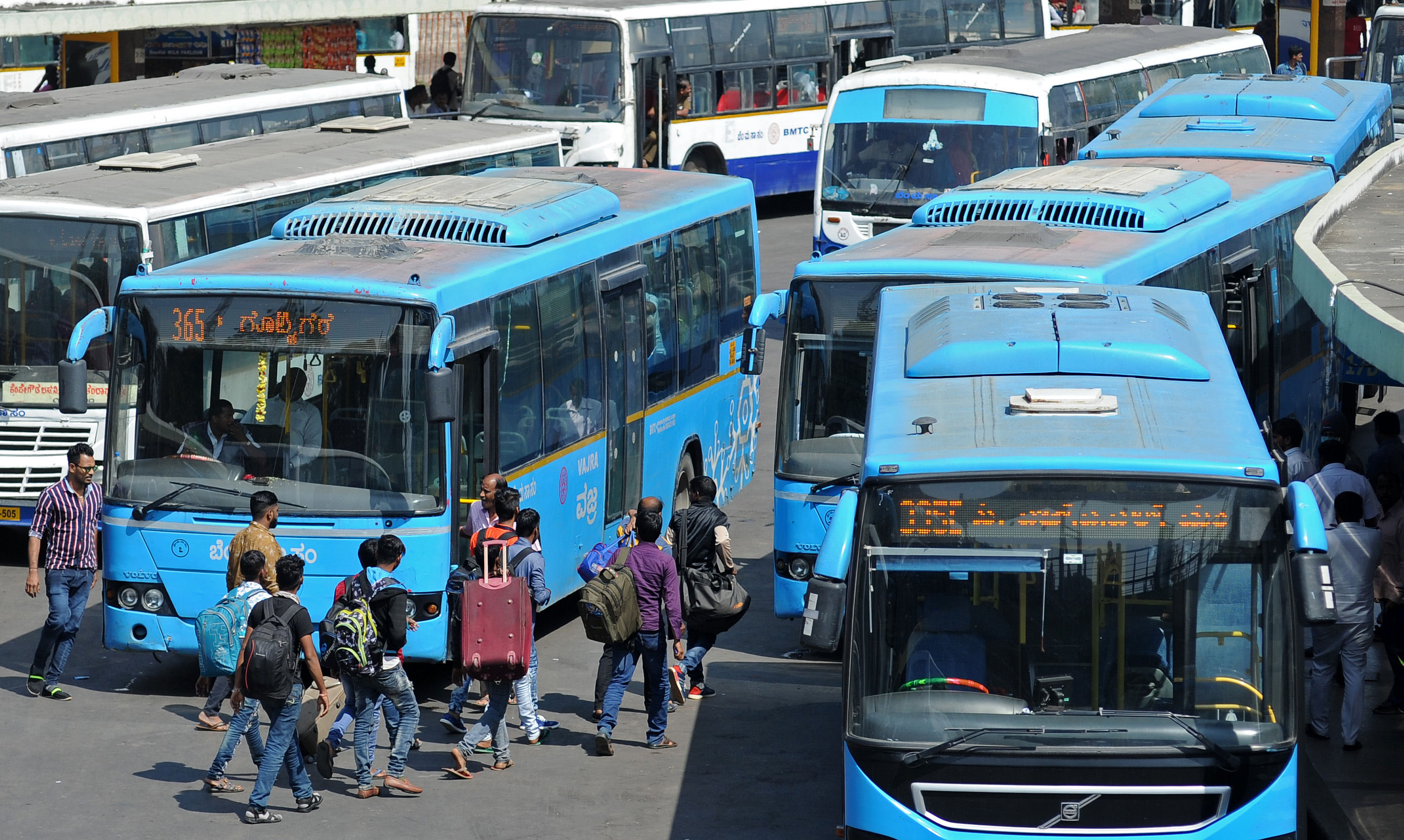 People seen boarding buses at BMTC bus terminal at Majestic in Bengaluru. (DH Photo)