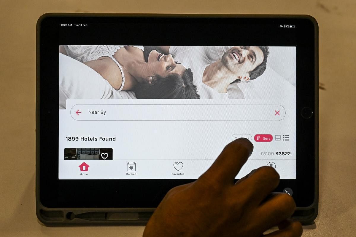 In this photo taken on February 11, 2020 a man uses an app on a tablet to book a couple-friendly hotel room in Mumbai. (AFP Photo)