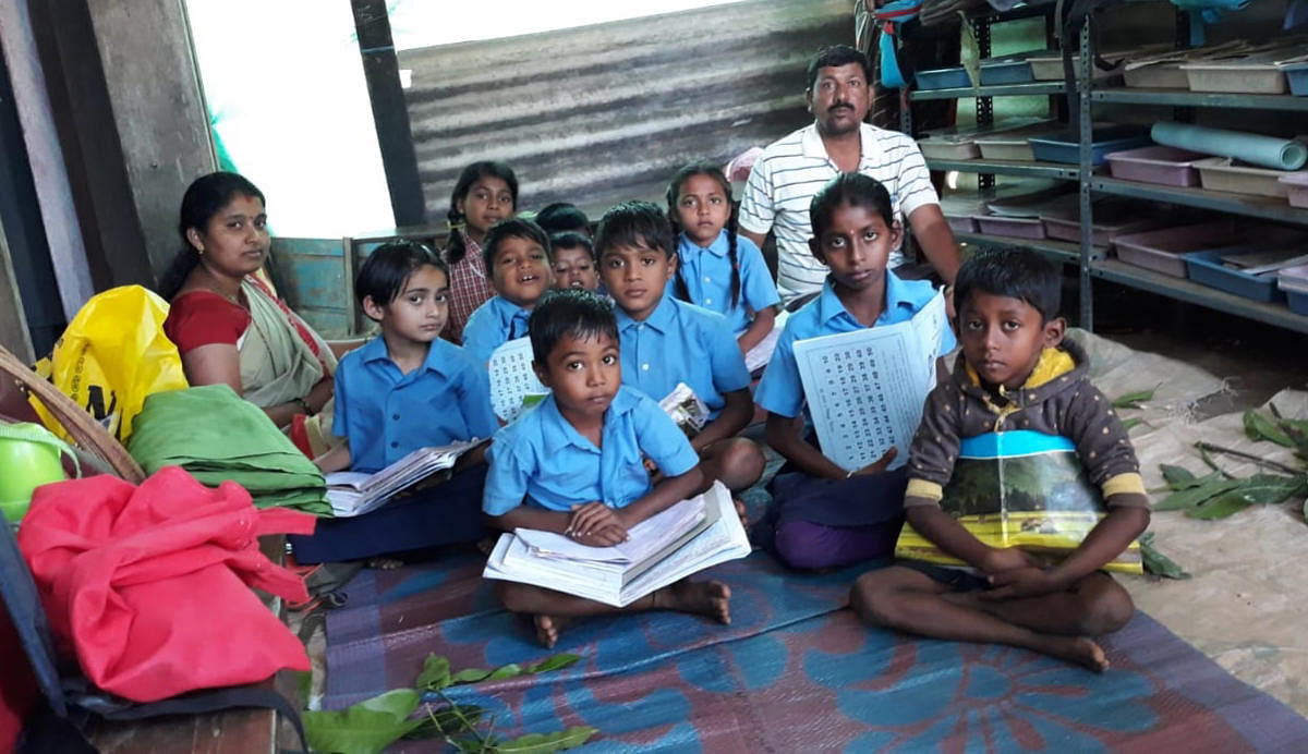 Children and teachers sit inside the makeshift classroom.