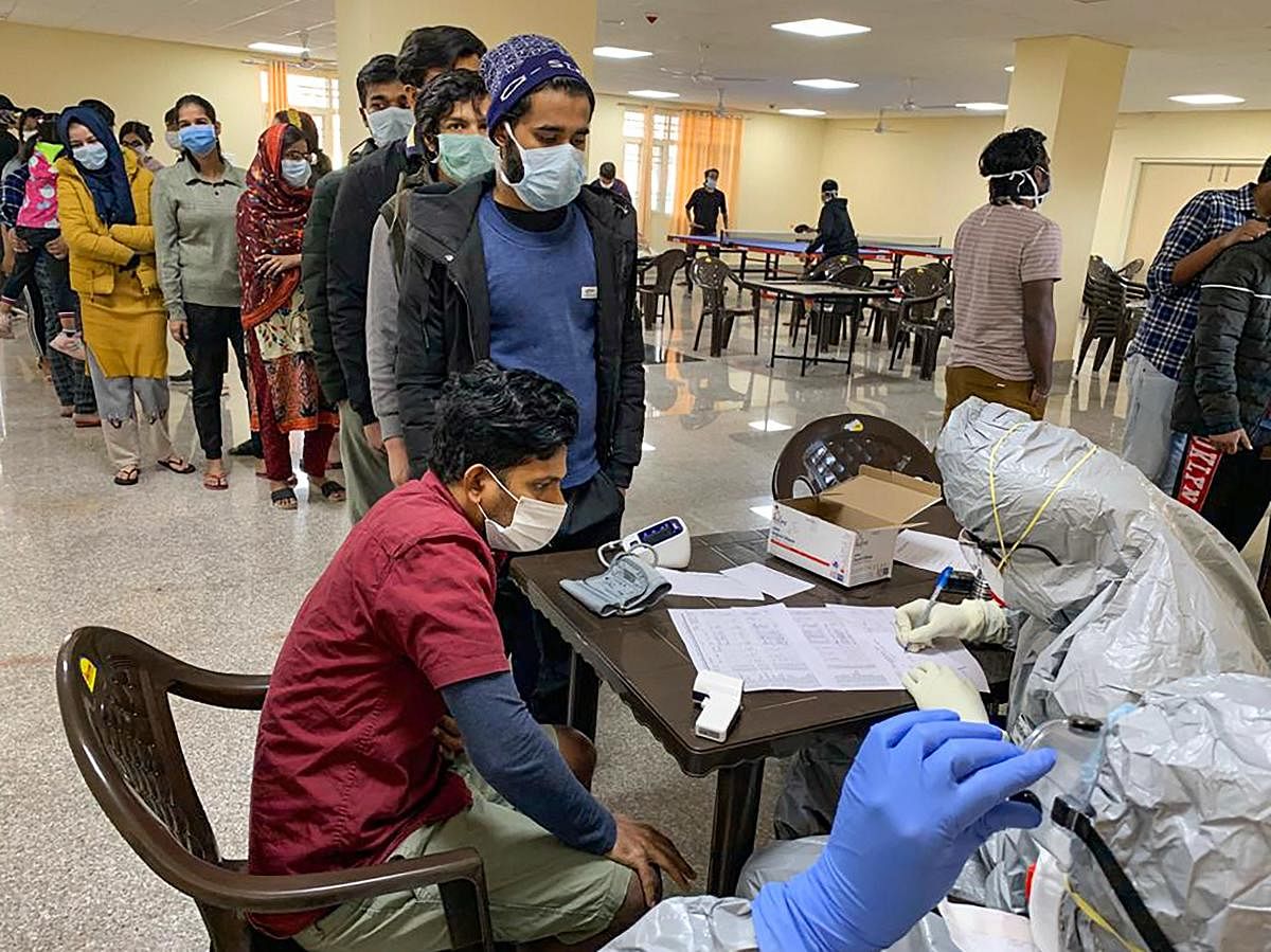 In this handout photo provided by Indo-Tibetan Border Police (ITBP), Indian nationals who were airlifted from coronavirus-hit Hubei province of China's Wuhan, undergo screening at a quarantine facility set by up ITBP, at Chhawla area in New Delhi, Saturday, Feb. 15, 2020. (PTI Photo)