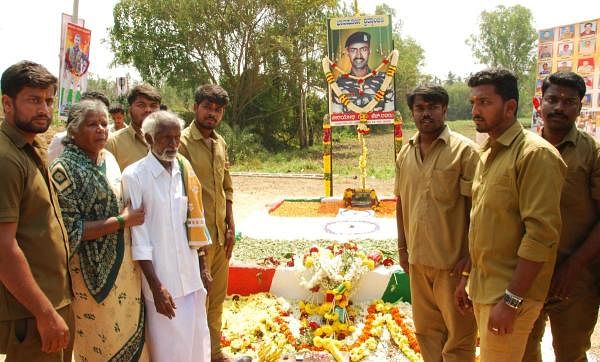 Martyred constable H Guru's parents and students pay respects to the memorial at Gudigere Colony, Maddur taluk, Mandya district, on Friday. (DH Photo)