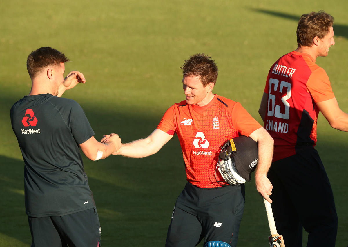 England's Eoin Morgan celebrates winning with teammates at the end of the match. Reuters