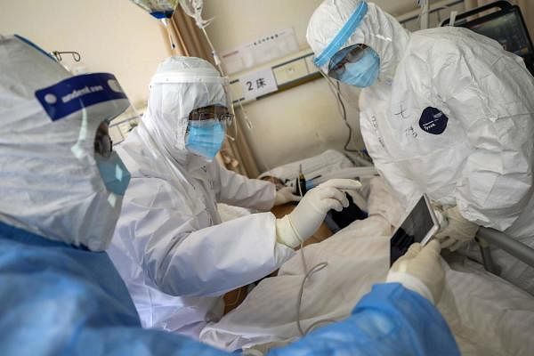 In this Sunday, Feb. 16, 2020, photo, medical personnel scan a new coronavirus patient at a hospital in Wuhan in central China's Hubei province. (AFP Photo)