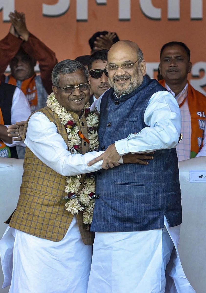 Former Jharkhand chief minister Babulal Marandi (L) greets Union Minister Amit Shah during the merger of Jharkhand Vikas Morcha with the Bharatiya Janata Party (BJP), at an event, in Ranchi, Monday, Feb. 17, 2020. (PTI Photo)