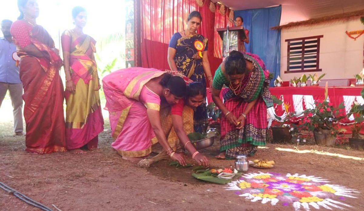 Women offer coconut oil to the earth as a part of 'Keddasa' ritual.