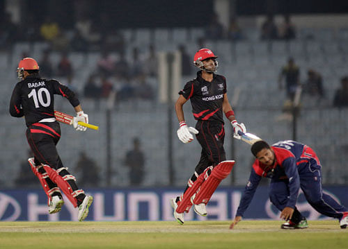Nepal's Basant Regmi, right, on ground fails to stop a ball as Hong Kong's Babar Hayat, left and Waqas Barkat score a run during their ICC Twenty20 Cricket World Cup match in Chittagong, Bangladesh, Sunday, March 16, 2014. AP
