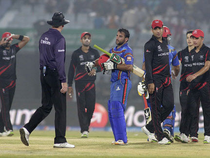 Afghan batsmen, blue uniform, greet Hong Kong players after they won their ICC Twenty20 Cricket World Cup match in Chittagong, Bangladesh, Tuesday, March 18, 2014. Afghanistan won by seven wickets. AP photo