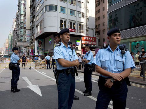 Police officers stand guard at a main road in the Mong Kok area in Hong Kong, Monday, Oct. 6, 2014. Student-led protests for democratic reforms in Hong Kong shrank Monday but a few hundred demonstrators remained camped out in the streets, vowing to keep up the pressure until the government responds to their demands. AP Photo