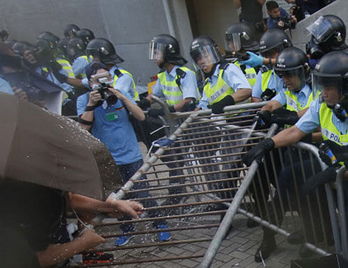 Hong Kong police officers involved in an apparent assault on a protester have been 'removed' from their positions, the city's security chief said today, after video emerged of a handcuffed man being beaten and kicked. AP file photo
