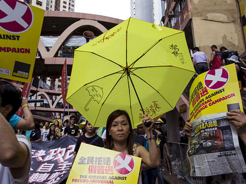 Pro-democracy protester holds a yellow umbrella, the symbol of the Occupy Central movement, during a march to demand lawmakers reject a Beijing-vetted electoral reform package for the city's first direct chief executive election in Hong Kong, China. REUTERS