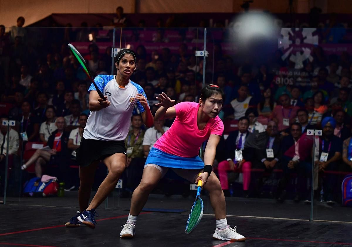 Hong Kong's Annie Au Wing-chi (right) hits a return against India's Joshna Chinappa in their women's team squash final match. AFP 