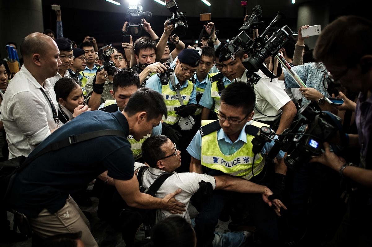 In this file photo taken on June 14, 2014, policemen remove protesters from the grounds of the Legislative Council in Hong Kong. AFP
