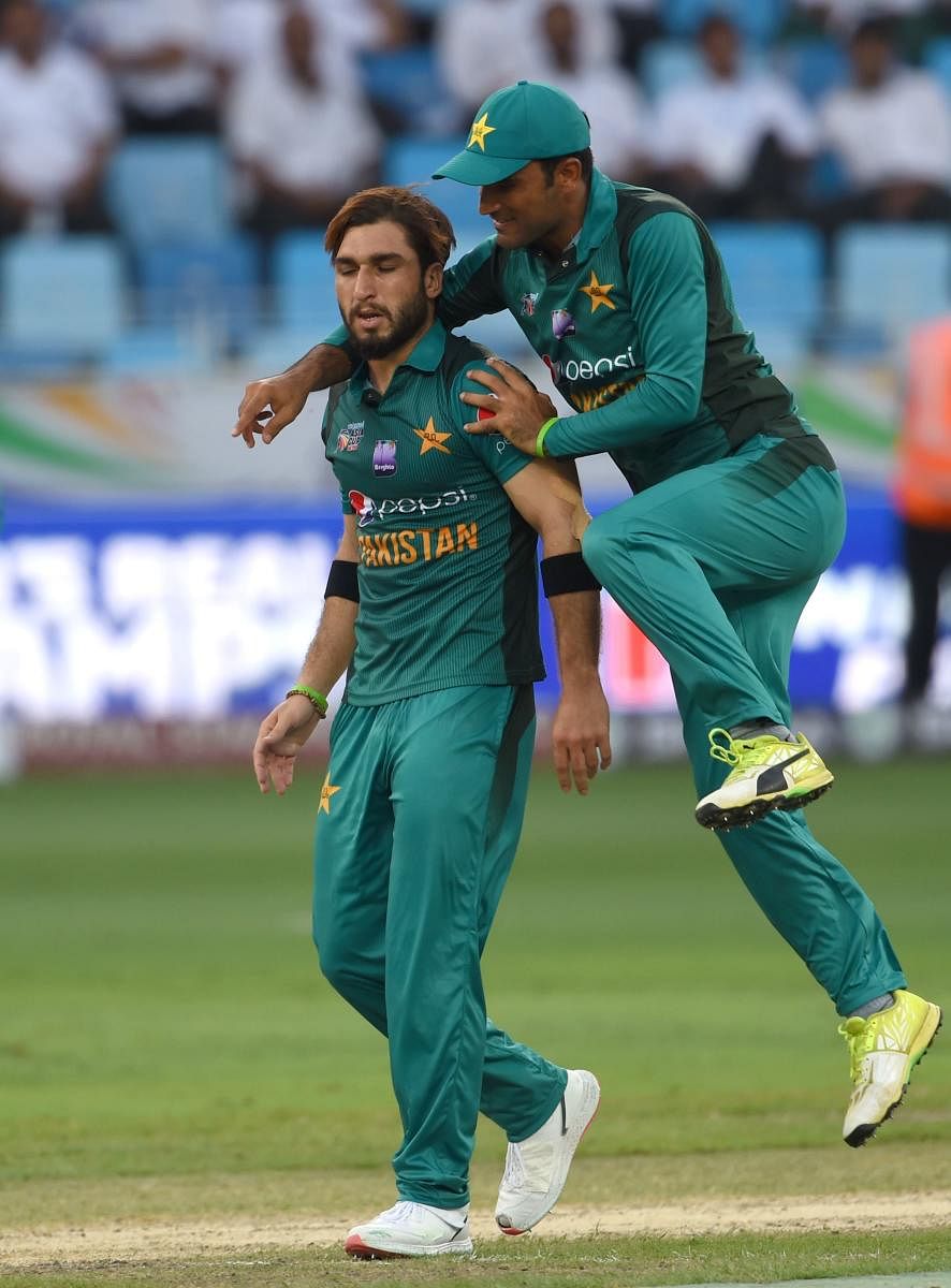 Easily done: Pakistan’s Usman Khan is congratulated by a team-mate after dismissing Hong Kong batsman Scott McKechnie during their Asia Cup match on Sunday. AFP
