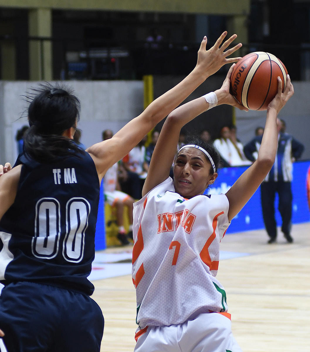 Harshitha K B of India about to score psat Tan Fung of Hong Kong in the FIBA U-18 Women's Asian Basketball Championship at the Sree Kanteerava Indoor Stadium in Bengaluru on Friday. DH Photo/ Srikanta Sharma R
