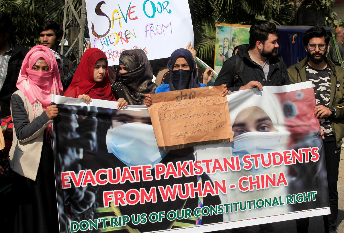  People and family members hold signs and banner demanding evacuation of Pakistani students from Wuhan city in China, who couldn’t go back after the coronavirus outbreak, during a protest outside Chinese Consulate in Lahore. Credit: Reuters Photo
