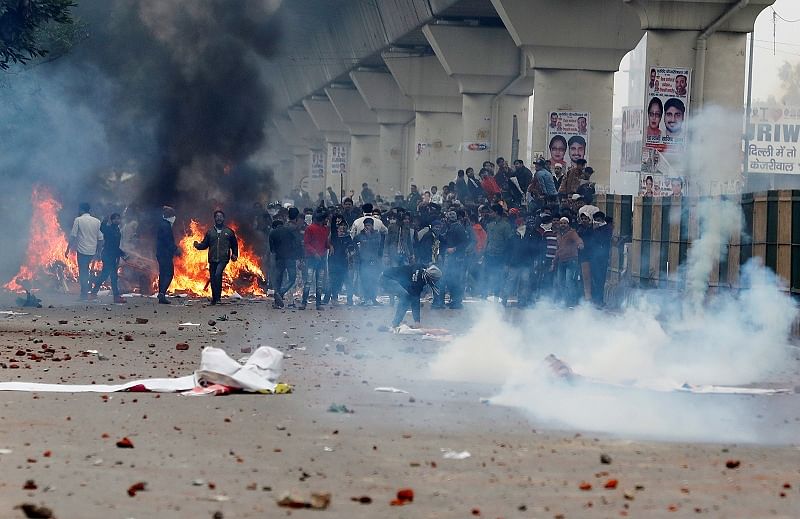 Demonstrators throw stones towards police during a protest against a new citizenship law in Seelampur, area of Delhi. (Reuters Photo)