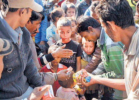 Food being distributed to displaced tribals at a relief camp in Sonitpur. PTI